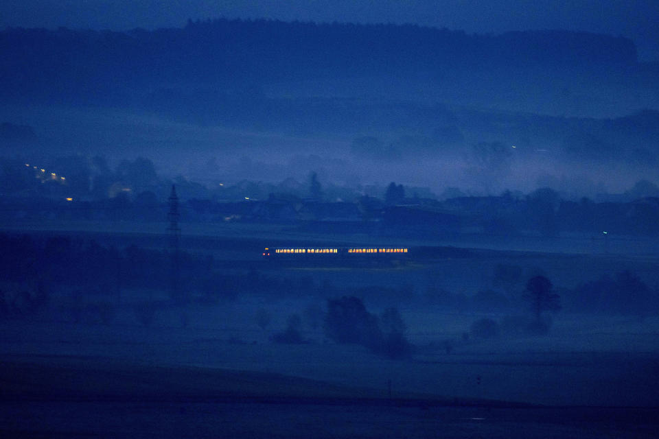 A regional train travels through the outskirts of Frankfurt, Germany, on a misty Thursday morning, April 28, 2022. (AP Photo/Michael Probst)