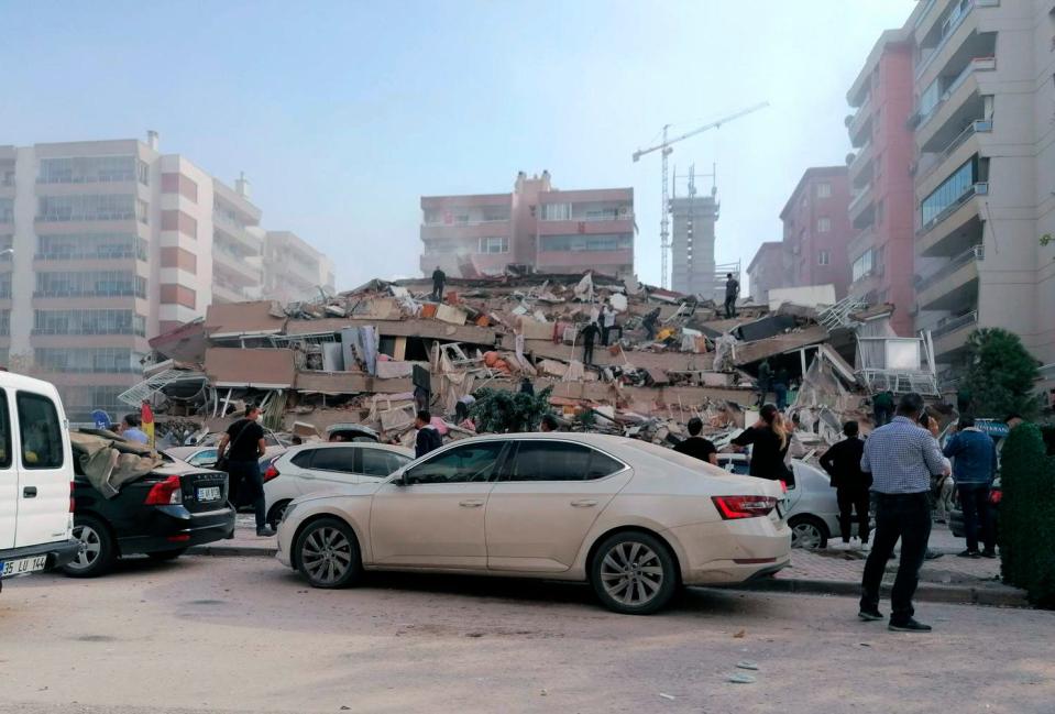 People work on a building reduced to rubble in Izmir, Turkey, Oct. 30, 2020, after a strong earthquake in the Aegean Sea shook Turkey and Greece.