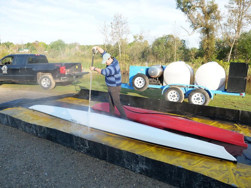 Water resources education coordinator Eli Baker uses the watershed council’s Mobile Boat Washing Station to clean a kayak prior to Paddle Antrim at Ellsworth River Park. The spray of hot water can dislodge aquatic invasive species and prevent their spread between water bodies.