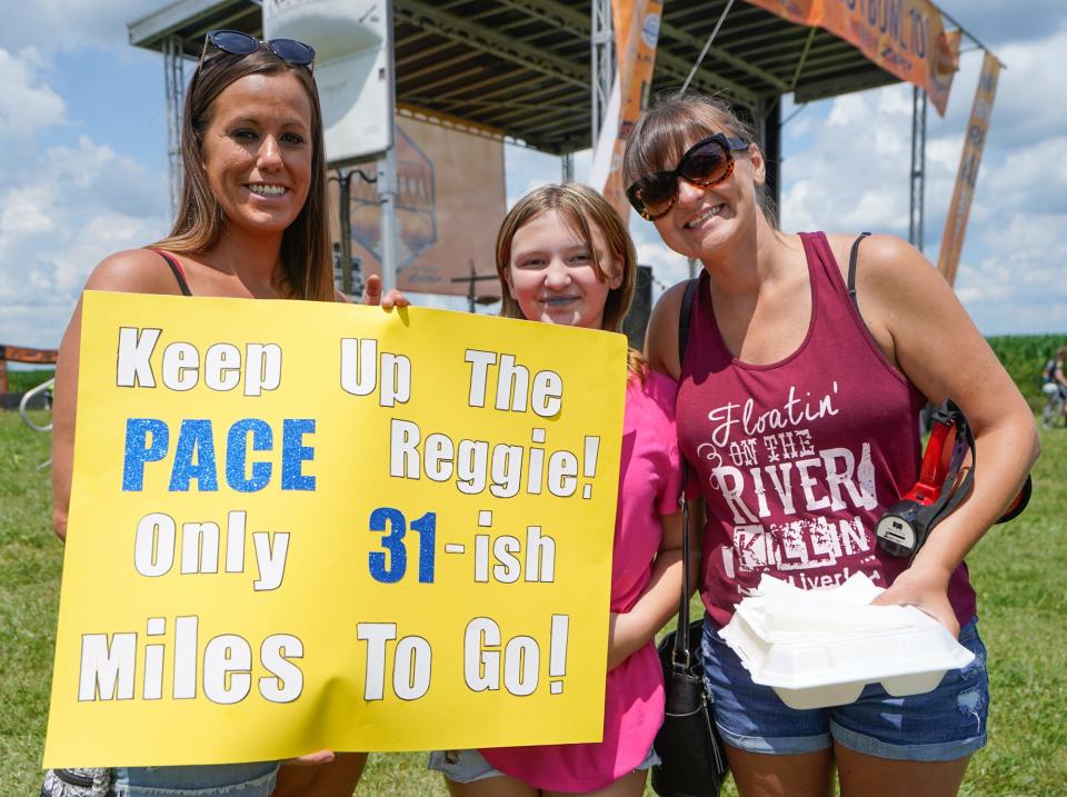 From left, Melissa Wool, Melea Berry and Pam Berry hold a sign for retired Indiana Pacers player Reggie Miller who completed the Dustbowl 100 gravel bicycle race on Saturday, July 22, 2023, in Eminence Ind.
