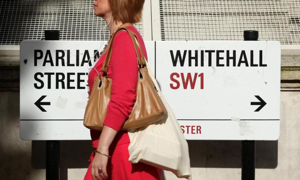 A woman walks past signs in Westminster, London