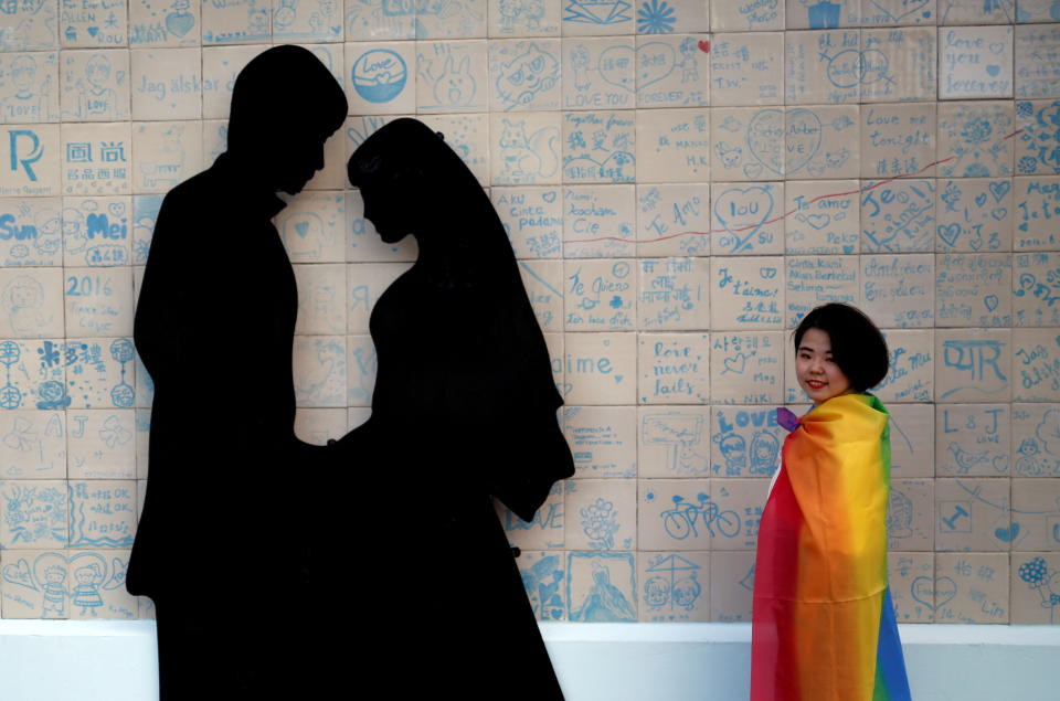 A participant poses next to a wedding studio during a lesbian, gay, bisexual and transgender pride parade to support same-sex marriage in Taipei, Taiwan on 27 October, 2018. (PHOTO: Reuters)