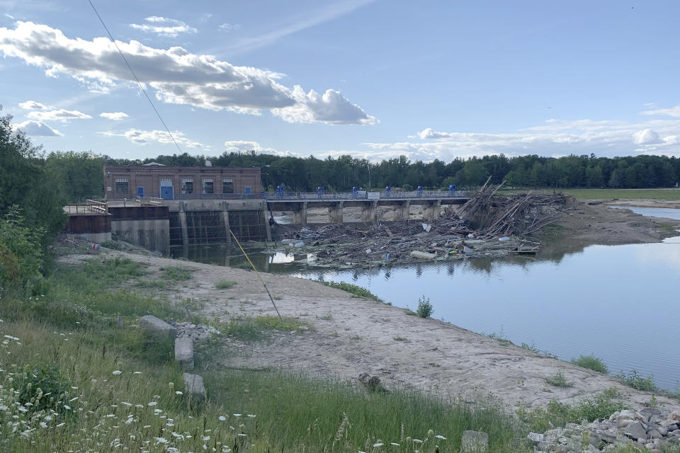 Debris rests at the spillway of the Sanford Dam in downtown Sanford, Michigan, July 30, 2020. The Four Lakes Taskforce wants to gain ownership of the Sanford Dam and three others after two of them failed in May, draining a string of lakes and flooding homes and businesses. (AP Photo/ Jeff McMillan)