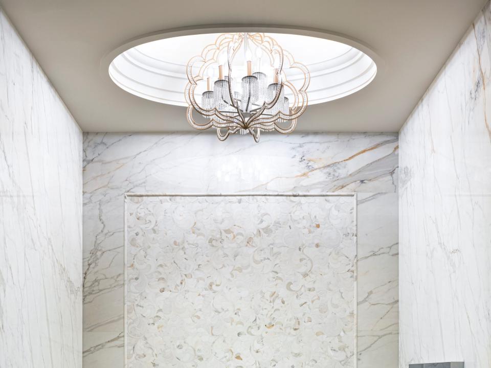 a large marble soaking tub under a skylight