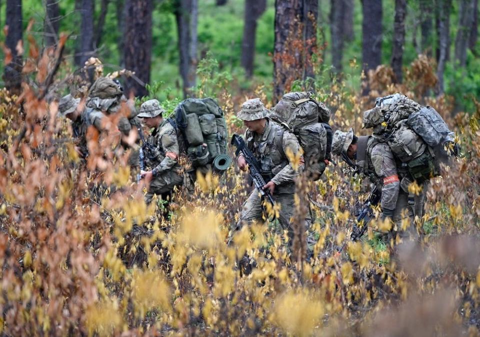 Special Forces candidates assigned to the U.S. Army John F. Kennedy Special Warfare Center and School walk through a wooded area May 27, 2023, during the final phase of field training known as Robin Sage in central North Carolina.