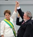 <p>La présidente brésilienne Dilma Rousseff portait une veste blanche lors de son investiture au cours de laquelle elle a reçu l'écharpe présidentielle des mains du président sortant Luiz Inacio Lula da Silva le 1er janvier 2011. <i>(Photo : EVARISTO SA/AFP/Getty Images)</i></p>