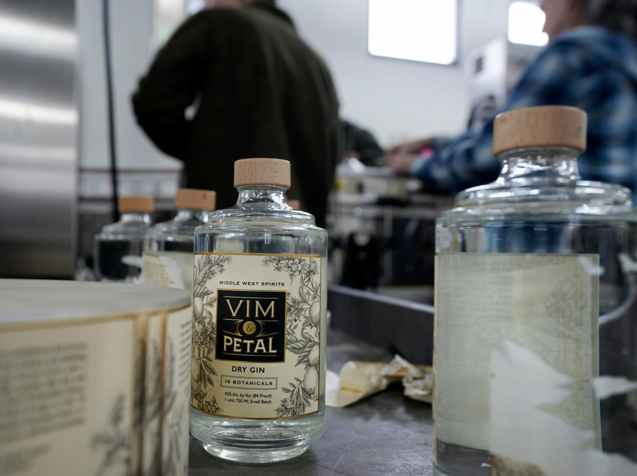 Bottles of gin are filled and labeled in the new Middle West Spirits distillery.