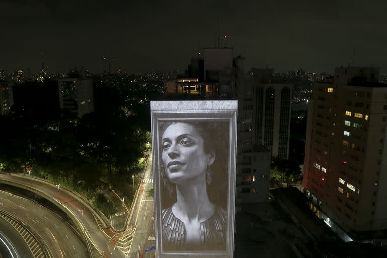 TOPSHOT - An image of slain Brazilian rights activist and politician Marielle Franco is projected on the side of the Anchieta Building on the fifth anniversary of her murder, as part of a homage paid by visual artist Alexis Anastasiou to murdered human rights activists, in Sao Paulo, Brazil, on March 14, 2023. - Marielle and her driver Anderson Gomes were killed five years ago and despite some arrests and a lot of social pressure calling for justice, their murder remains unsolved. (Photo by Miguel SCHINCARIOL / AFP)