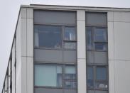 A woman looks out of a window in the Dorney Tower residential block, as residents were evacuated as a precautionary measure following concerns over the type of cladding used on the outside of the building in north London, Britain, June 24, 2017. REUTERS/Hannah McKay