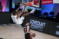 Indiana Pacers forward T.J. Warren (1) hangs on the rim over Miami Heat guard Goran Dragic (7) after he scored during the second half of an NBA basketball first round playoff game, Saturday, Aug. 22, 2020, in Lake Buena Vista, Fla. (AP Photo/Ashley Landis, Pool)