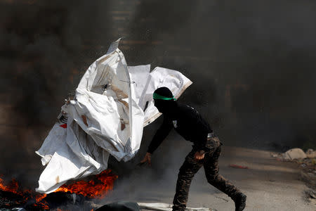A Palestinian protester reacts during clashes with Israeli troops near the Jewish settlement of Beit El, in the Israeli-occupied West Bank March 20, 2019. REUTERS/Mohamad Torokman