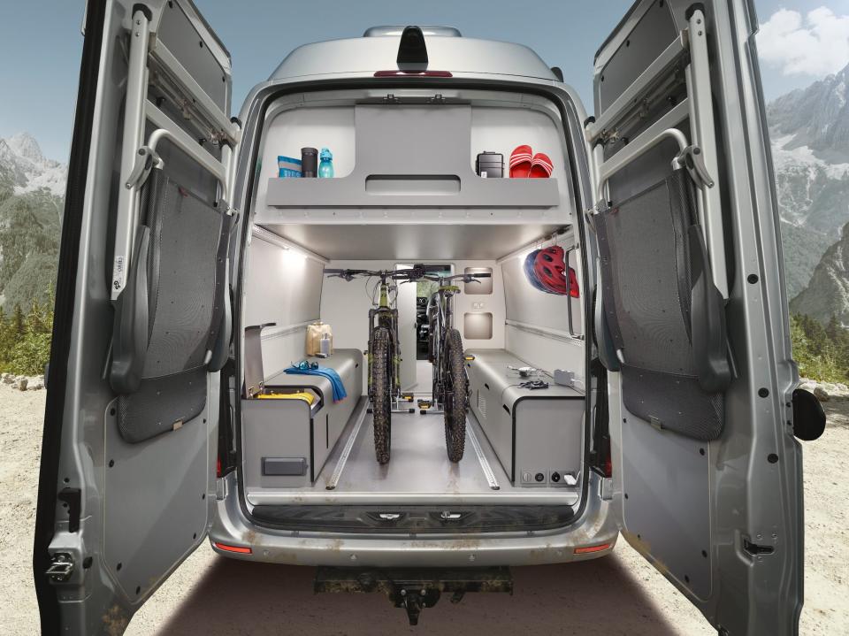 The rear of the camper van with a garage-like space. Two bikes are inside.