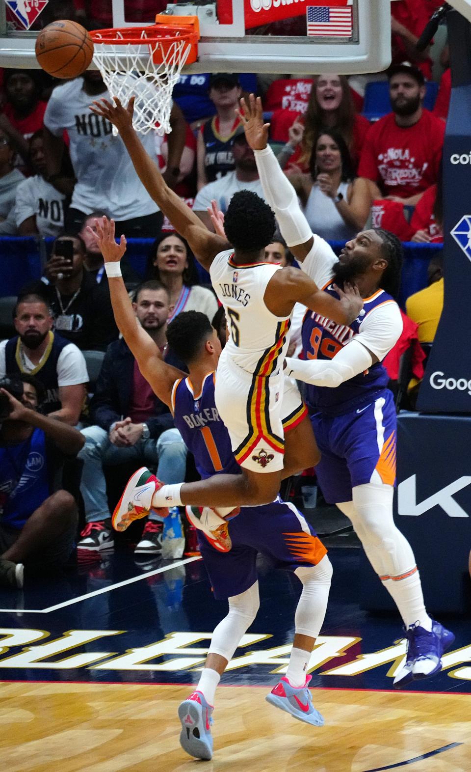 Pelicans' Herbert Jones (6) makes a layup between Suns' Jae Crowder (99) and Devin Booker (1) during Game 6 of the first round of the Western Conference Playoffs.