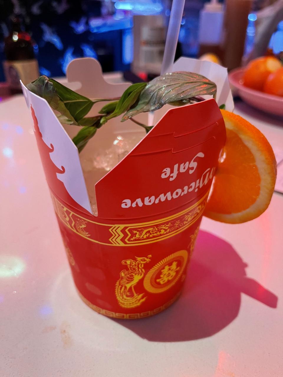 The Mai Thai at Cham Pang Lanes is made with rum, Curaçao, Orgeat and lime. It's served inside a food takeout container.