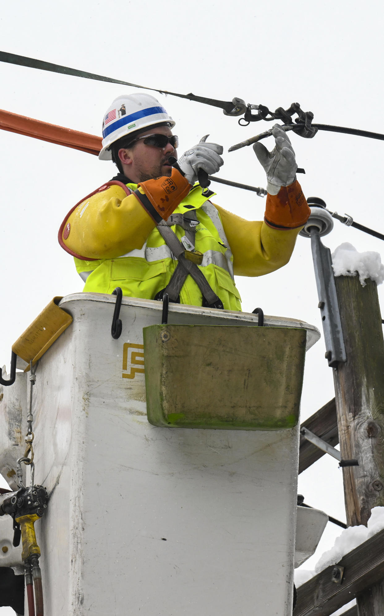 National Grid lineman, Jim Sheeran repairs a primary power line during a winter snow storm Tuesday, March 14, 2023, in Ballston Lake, N.Y. (AP Photo/Hans Pennink)