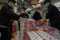 Customers queue to buy supplies of toilet paper in a supermarket in Hong Kong, Friday, Feb. 14, 2020. China on Friday reported another sharp rise in the number of people infected with a new virus, as the death toll neared 1,400. (AP Photo/Kin Cheung)