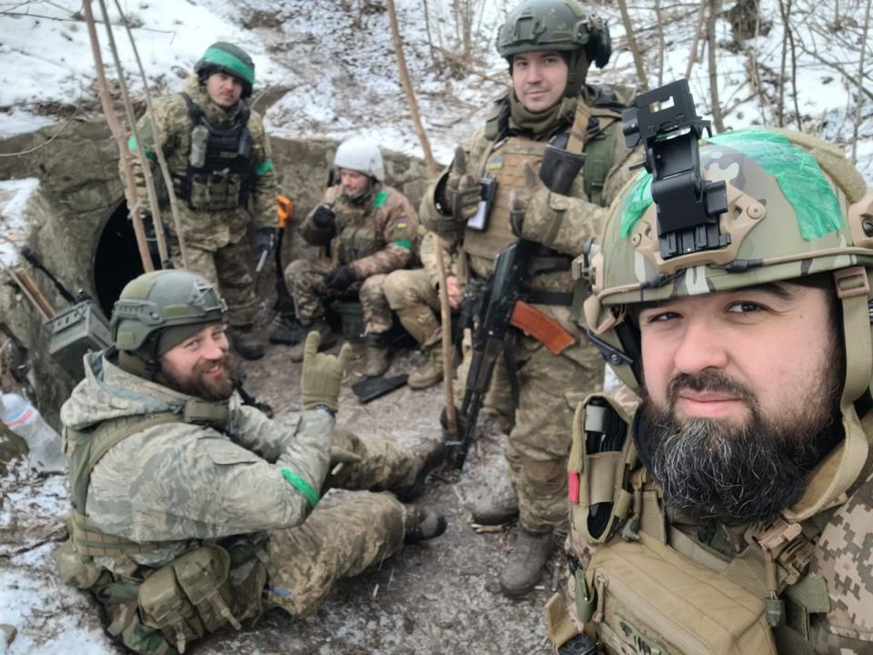 Oleksander Pleskov in a selfie in a snow-dusted trench environment with four fellow soldiers in February.