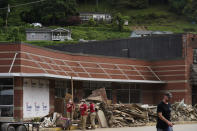 Volunteers help clean up dirt and debris off of the main street in downtown Fleming-Neon, Ky., on Friday, Aug. 5, 2022. The previous week's massive flooding damaged much of the town. (AP Photo/Brynn Anderson)