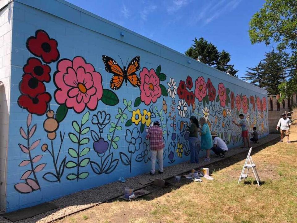 Cambria volunteers work in July 2023 to complete a mural on a wall of Re-Create Thrift Shop in Cambria.