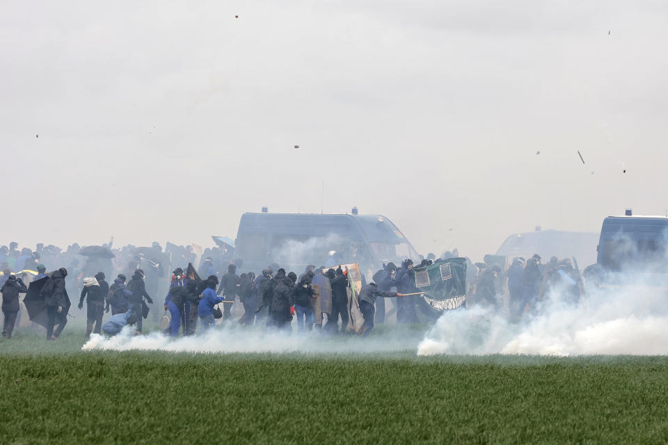 Des manifestants, entourés de gaz lacrymogènes, affrontent des gendarmes mobiles anti-émeute lors d’une manifestation pour protester contre la construction d’une nouvelle réserve d’eau pour l’irrigation agricole, à Sainte-Soline, dans les Deux-Sèvres, le 25 mars 2023.