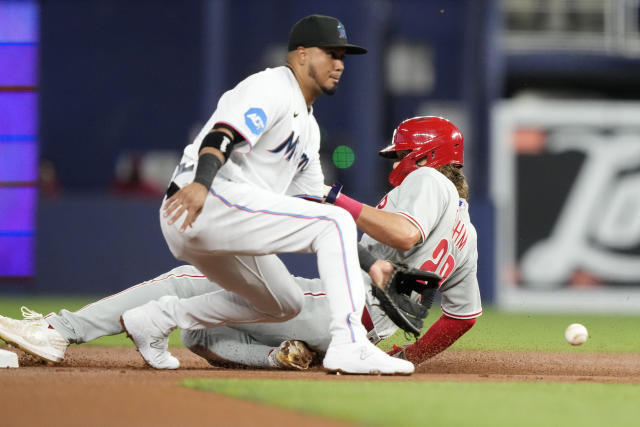 Miami Marlins' Jean Segura, left, is out at the plate on a throw from  Philadelphia Phillies second baseman Bryson Stott to catcher J.T. Realmuto,  right, during the eighth inning of a baseball