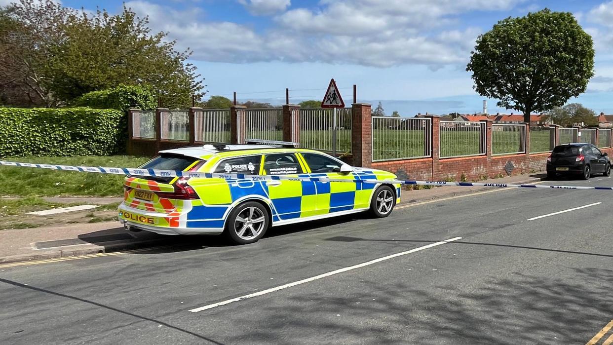 Police car and police tape cordon