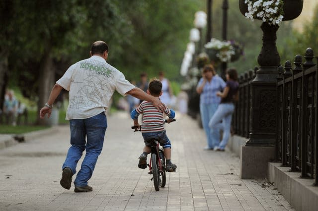 A young boy learning to ride a bike