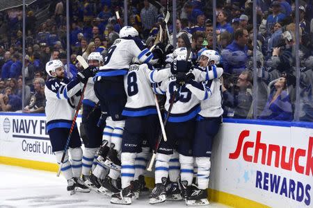 Apr 16, 2019; St. Louis, MO, USA; Winnipeg Jets left wing Kyle Connor (81) is mobbed by teammates after scoring the game winning goal against St. Louis Blues goaltender Jordan Binnington (not pictured) during overtime in game four of the first round of the 2019 Stanley Cup Playoffs at Enterprise Center. Mandatory Credit: Jeff Curry-USA TODAY Sports