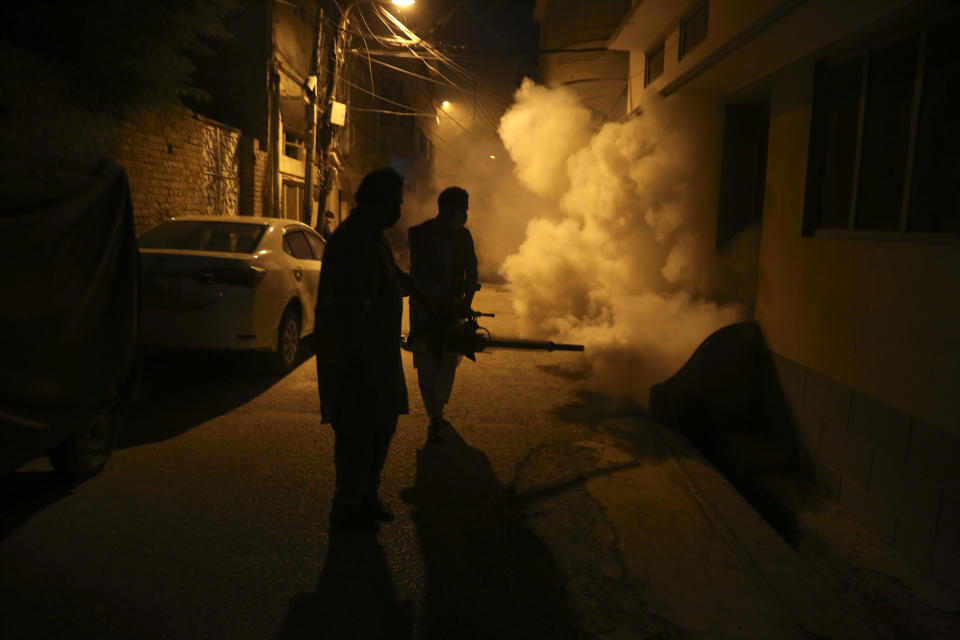 Pakistani health workers fumigate to kill mosquitos in an effort to prevent an outbreak of dengue fever, in Peshawar, Pakistan. Friday, Sept. 23, 2022. Pakistan has deployed thousands of additional doctors and paramedics in the country's worst flood-hit province to contain the spread of diseases that have killed over 300 people among the flood victims, officials said Friday. (AP Photo/Muhammad Sajjad)