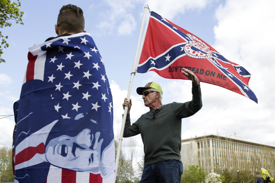 Keith Weber of Centralia, Washington, holds a flag that combines a Gadsden flag from the American Revolution with a Confederate flag from the American Civil War as people demonstrate against Washington state's stay-home order at the state capitol in Olympia, Washington, on April 19, 2020. (Photo: JASON REDMOND via Getty Images)