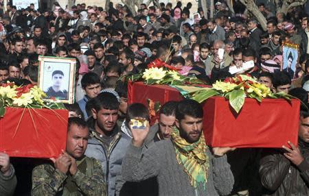 Men carry coffins of members of the Kurdish People's Protection Units (YPG) who were killed during clashes with the al Qaeda-affiliated Islamic State of Iraq and the Levant (ISIL), at Khirbet Al-Banat village in the Ras al-Ain countryside, in this December 24, 2013 file photo. REUTERS/Rodi Said/Files