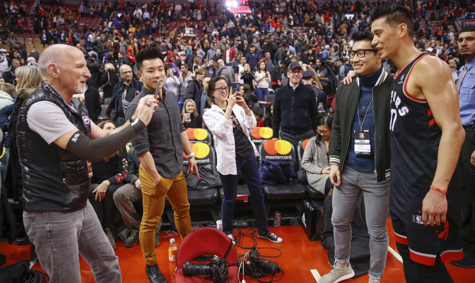 TORONTO, ON - MARCH 18: Raptors team photographer Ron Turenee snaps a photo of Simu Liu (of Kim's Convenience TV show) and Toronto Raptors guard Jeremy Lin (17) following the game. Toronto Raptors vs New York Knicks in 2nd half action of NBA regular season play at ScotiaBank Arena. Raptors won 129-92. Toronto Star/Rick Madonik        (Rick Madonik/Toronto Star via Getty Images)