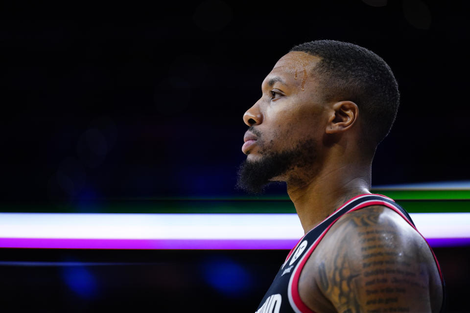 A side profile shot of Damian Lillard looking on during a game.