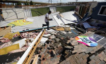 Benjamin Luna helps recover items from the children's wing of the First Pentecostal Church that was destroyed by Hurricane Laura, Thursday, Aug. 27, 2020, in Orange, Texas. (AP Photo/Eric Gay)