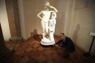 Giulio Manieri Elia, Director of the Accademia Gallery points the level reached by the water at the base of plaster cast sculpture 'Paride' by Antonio Canova, at the Accademia gallery, during an interview with The Associated Press in Venice, Saturday, Nov. 16, 2019. As high tidal waters returned to Venice on Saturday, four days after the city experienced its worst flooding in 50 years, young Venetians are responding to the worst flood in their lifetimes by volunteering to help salvage manuscripts, clear out waterlogged books and lend a hand where needed throughout the stricken city. (AP Photo/Luca Bruno)