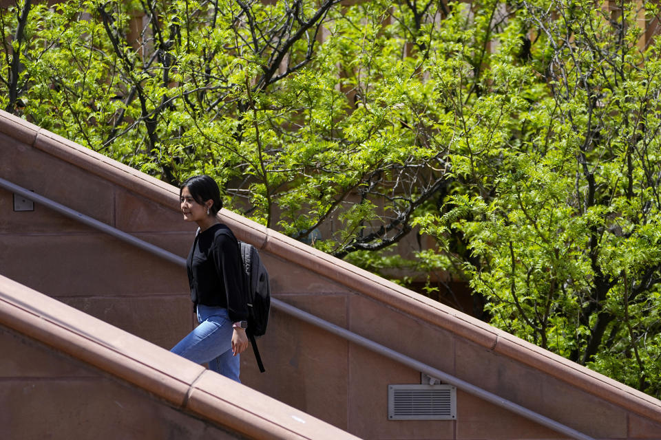 Fahima Sultani walks on campus at Arizona State University, Friday, April 7, 2023, in Tempe, Ariz. Sultani and others tried for days in the summer of 2021 to get into the Kabul airport, only to be turned away by the gun-wielding extremists as the Taliban swept back into power. After a harrowing escape, Sultani is one of more than 60 Afghan women who arrived at ASU in December 2021. (AP Photo/Matt York)