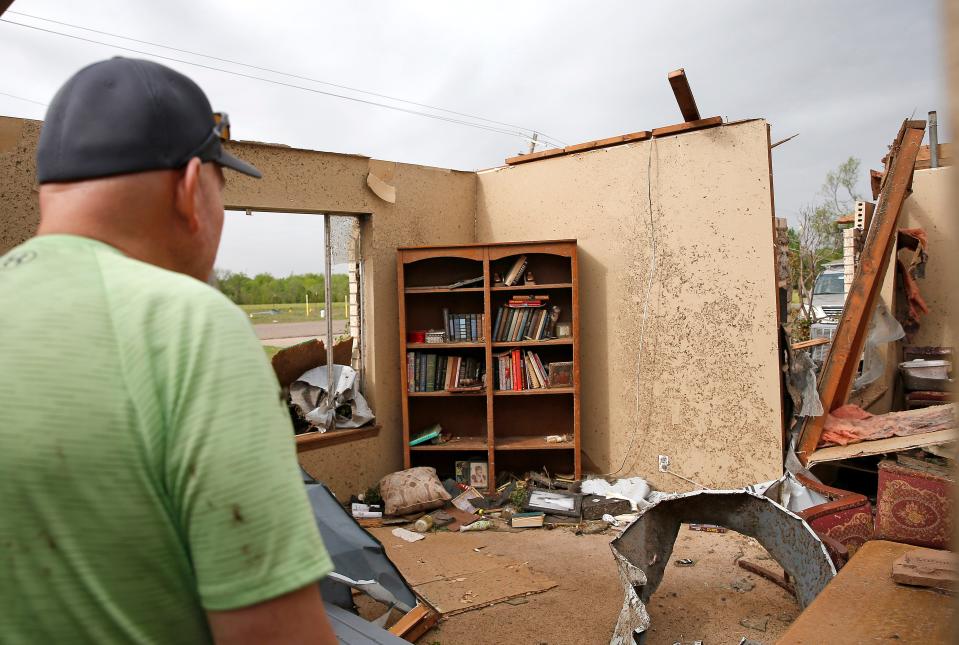 Jeff Totten looks at damage in his home,  Thursday, April, 20, 2023, in Shawnee, Okla., after tornado moved through the area Wednesday night in Shawnee, Okla.