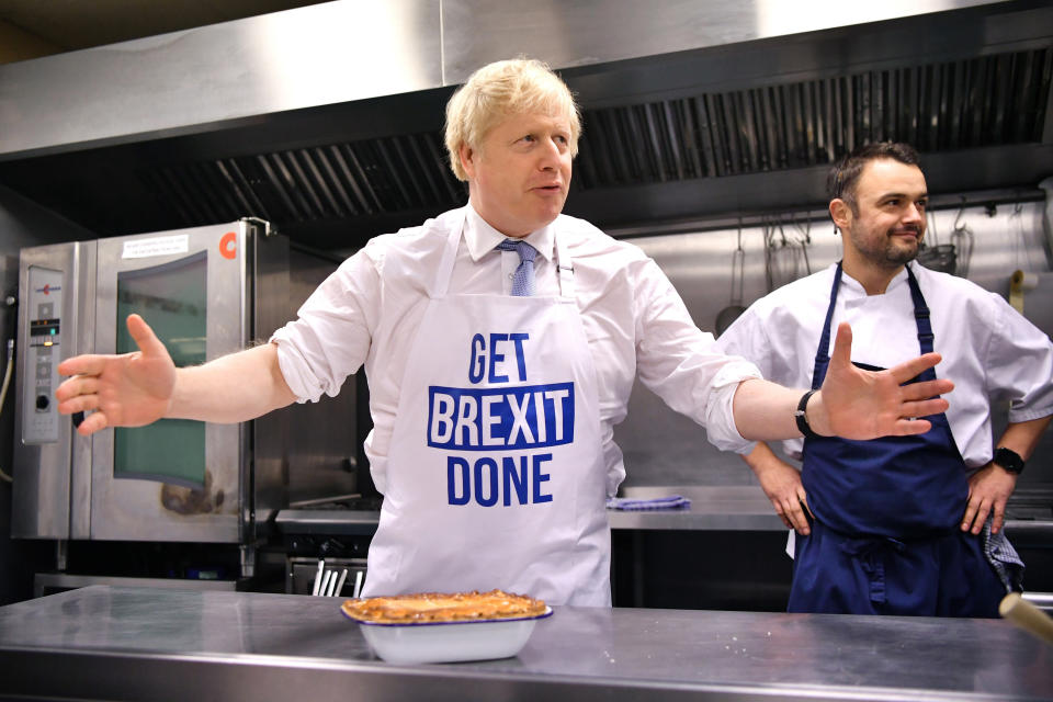 El primer ministro británico Boris Johnson prepara una tarta en la empresa de catering Red Olive, en Derby, Inglaterra, el miércoles 11 de diciembre de 2019. (Ben Stansall/Pool Photo vía AP)