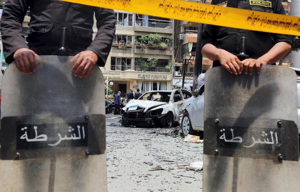 Policemen investigate the site of a car bomb attack on the convoy of Egyptian public prosecutor Hisham Barakat near his house at Heliopolis district in Cairo, Egypt, June 29, 2015. Barakat was injured when a car bomb struck his convoy as it was leaving his home in Cairo on Monday, in a high-profile attack against the judiciary, security and judicial sources said. (REUTERS/Mohamed Abd El Ghany)