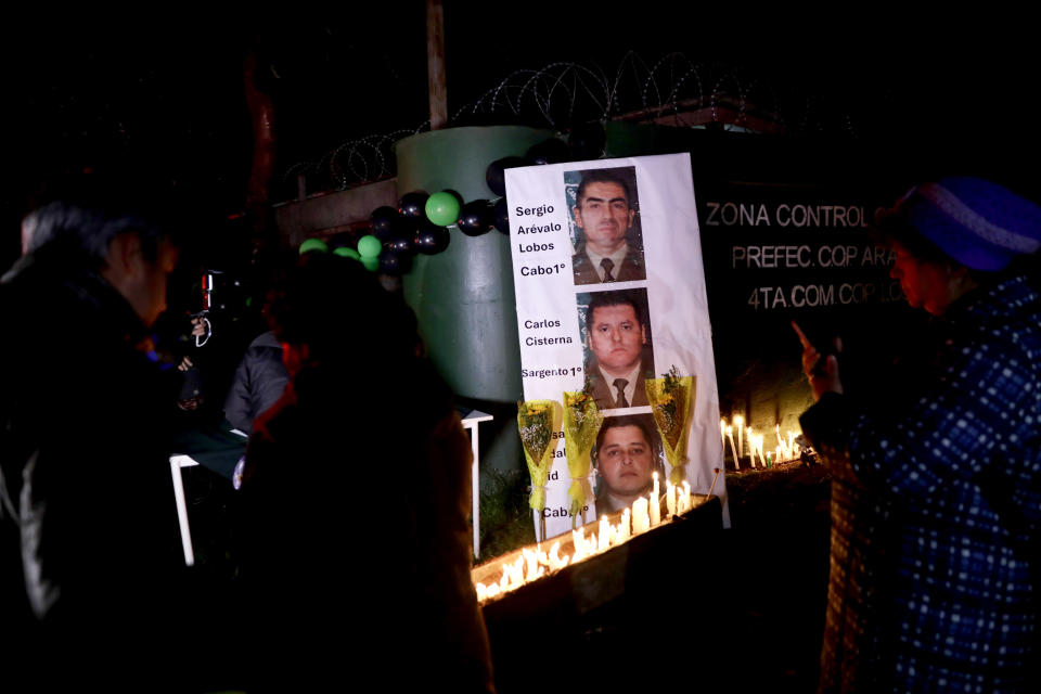 La gente enciende velas durante una vigilia por los policías asesinados en Cañete, Chile, el sábado 27 de abril de 2024. Asaltantes armados tendieron una emboscada y mataron a tres agentes del orden en el sur de Chile el sábado antes de prender fuego a su automóvil, dijeron las autoridades. (AP Foto/Amilix Fornerod)