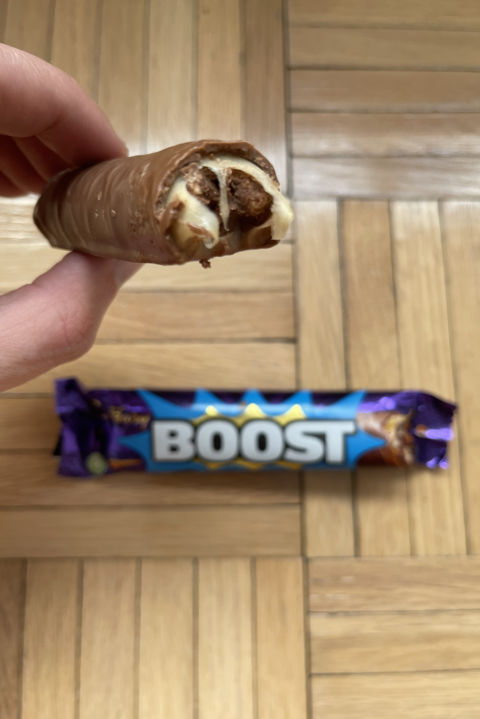 Hand holding a bitten Boost bar