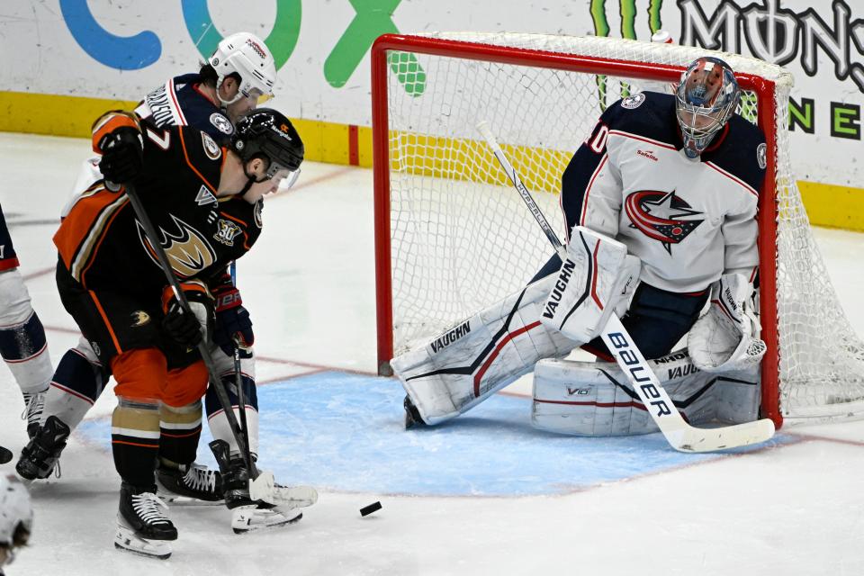 Anaheim Ducks right wing Frank Vatrano (77) and Columbus Blue Jackets defenseman Erik Gudbranson (44) vie for the puck in front of goaltender Daniil Tarasov, right, during the third period of an NHL hockey game in Anaheim, Calif., Wednesday, Feb. 21, 2024. (AP Photo/Alex Gallardo)