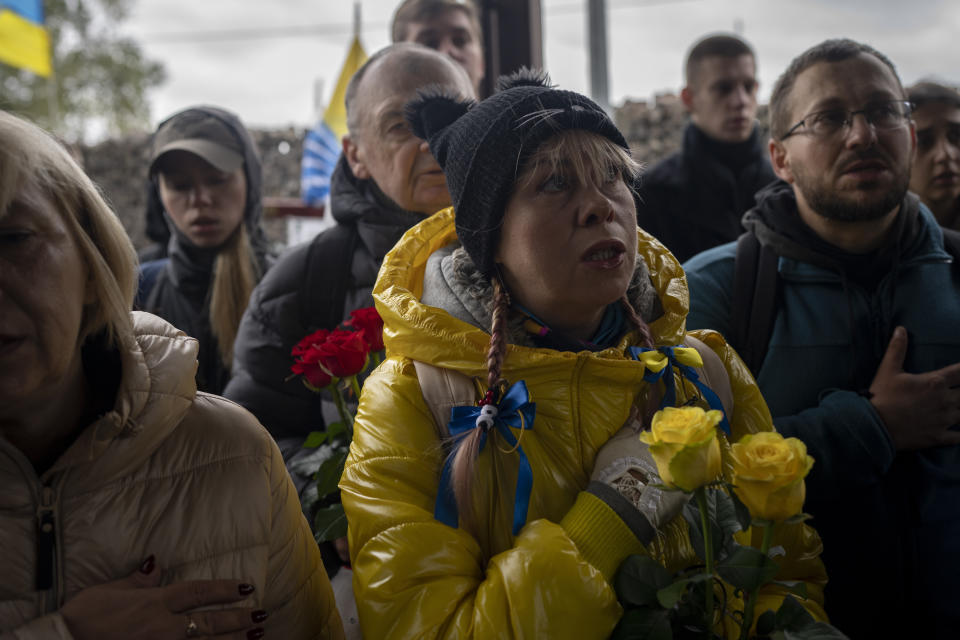 A woman sings the Ukrainian national anthem during the funeral of soldier Oleksandr Hrianyk in Kyiv, Ukraine, Saturday, Oct. 28, 2023. Hrianyk died in battle in May 2022 in the city of Mariupol, but was only cremated recently after his remains were found and identified. (AP Photo/Bram Janssen)