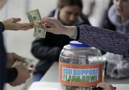 People donate money during a flash football game organized by Arlington High School football player Max Gray, 18, to raise money for Jonielle Spiller, the mother of youth football player Jovon "Jo Jo" Mangual, 13, who died during the Oso mudslide, in Arlington, Washington April 4, 2014. REUTERS/Jason Redmond