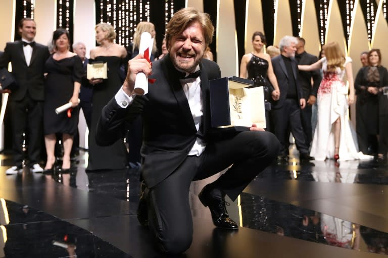 Swedish director Ruben Ostlund poses on stage with his trophy after he won the Cannes Film Festival's Palme d'Or for his film "The Square" on May 28, 2017