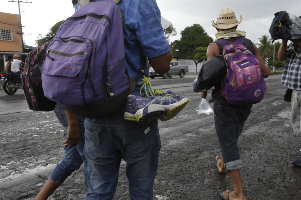 A pair of shoes hangs from the backpack of a Central American migrant arriving with a caravan of thousands to Xochiltepec, Mexico, Monday, Oct. 22, 2018. Thousands of Central American migrants resumed an arduous trek toward the U.S. border Monday, with many bristling at suggestions there could be terrorists among them and saying the caravan is being used for political ends by U.S. President Donald Trump. (AP Photo/Moises Castillo)