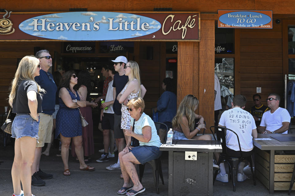 People wait outside to be seated at a restaurant at Heavenly Village in South Lake Tahoe, Calif., Monday, July 17, 2023. Tourism officials at Lake Tahoe were surprised, and a bit standoffish, when a respected international travel guide included the iconic alpine lake straddling the California line on a list of places to stay away from this year because of the harmful ecological effects of “over-tourism.” (AP Photo/Andy Barron)