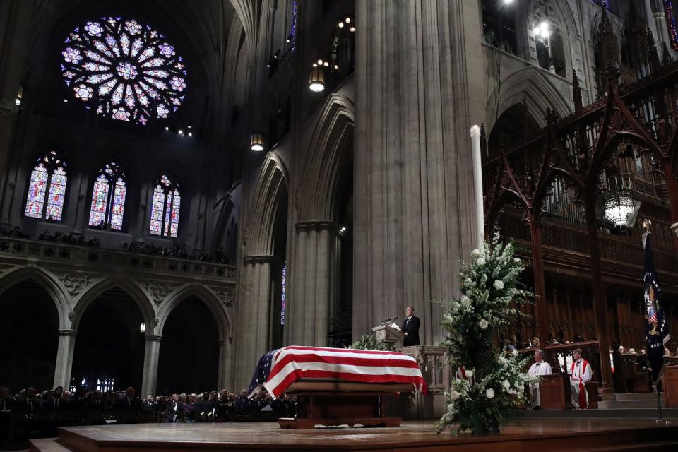 <p>Bush speaks in front of the flag-draped casket of his father.</p>