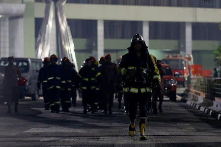 Firefighters come out of the Bangladesh Central Bank as fire is already under controlled in Dhaka, Bangladesh March 23, 2017. REUTERS/Mohammad Ponir Hossain