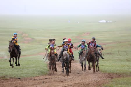 Child jockeys riding horses arrive to the finish line during a horse race at the Mongolian traditional Naadam festival, on the outskirts of Ulaanbaatar, Mongolia July 11, 2018. Picture taken July 11, 2018. REUTERS/B. Rentsendorj